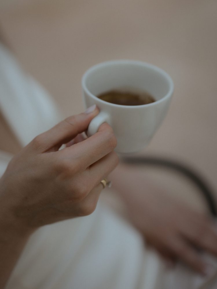 Detail of bride holding an espresso in her hand.